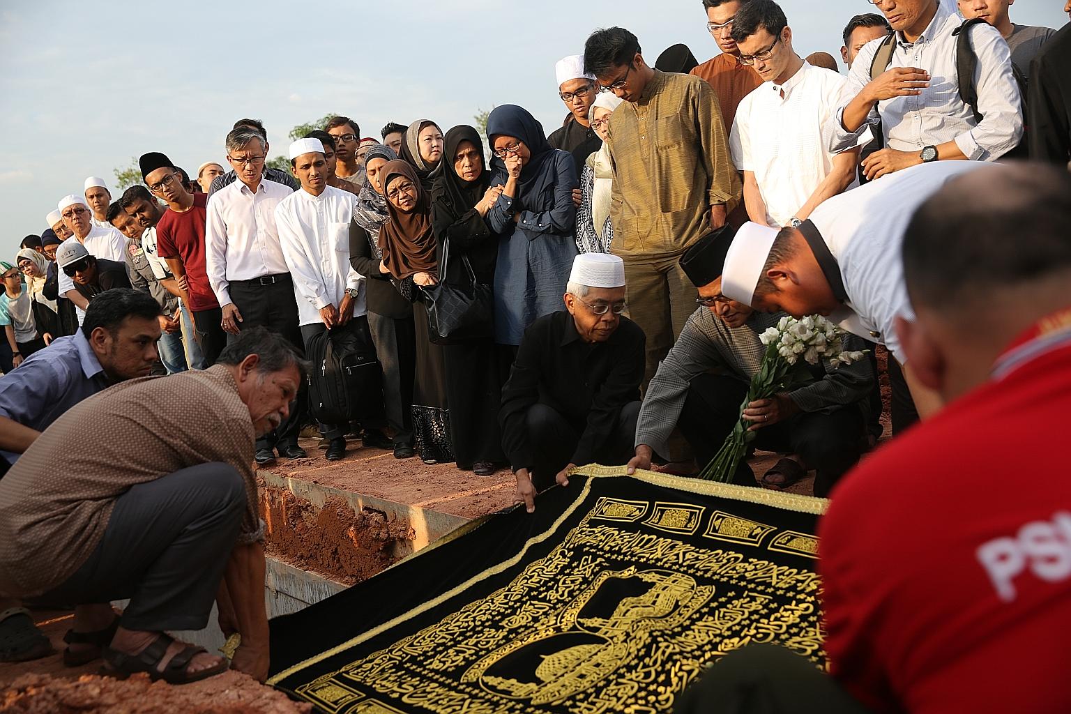 The burial (top) of Mr Mohammad Ghazi Mohamed (right) at the Pusara Aman cemetery yesterday. He leaves behind his wife Khalidal Huda Sukaimi, a teacher at East View Secondary School, and three children.