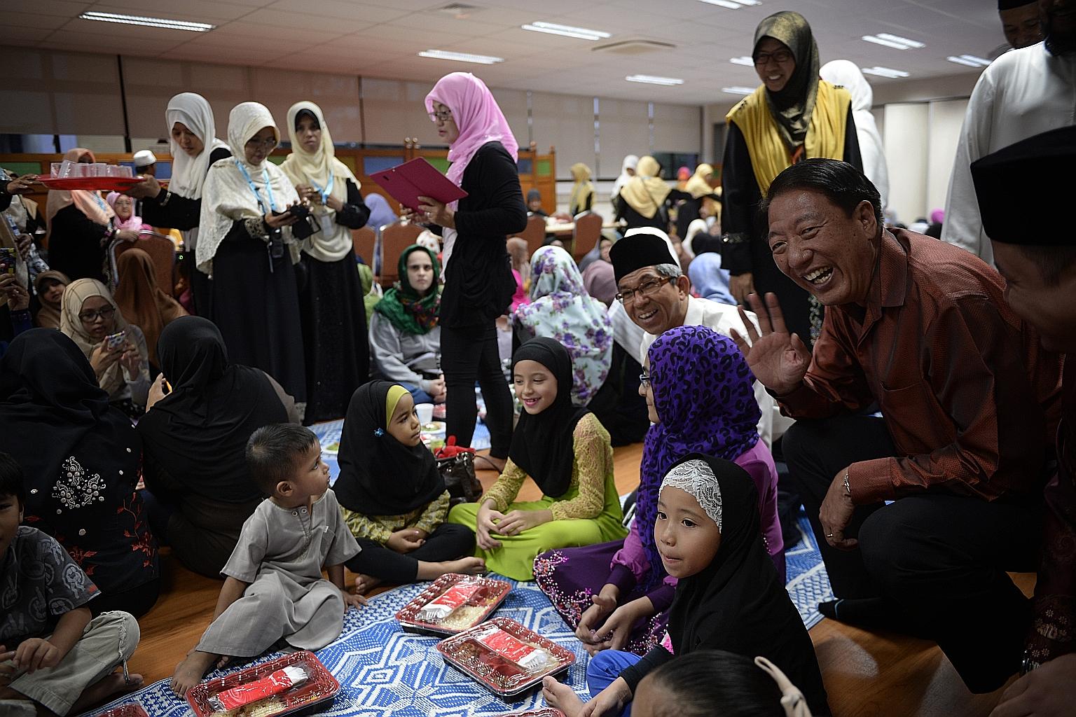 Deputy Prime Minister Teo Chee Hean (right) and Minister-in-charge of Muslim Affairs Yaacob Ibrahim (second from right) chatting with young Muslims breaking fast at Mujahidin Mosque in Commonwealth yesterday.