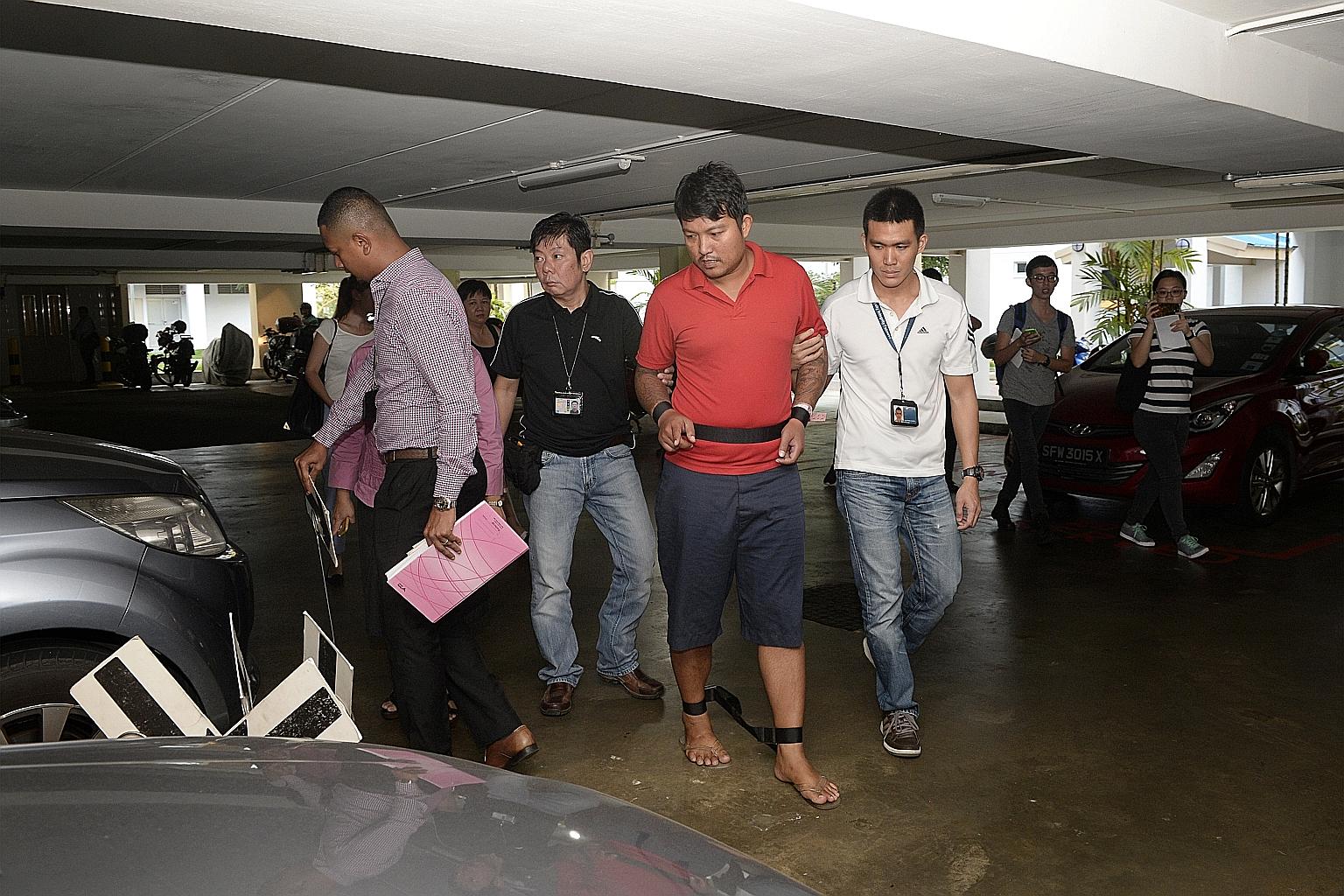 Police yesterday took Phyo Min Naing (in red) to the carpark in Pasir Ris where he and another man allegedly tasered a fellow Myanmar national on June 21. The suspects' alleged intention was to abduct and later murder him.