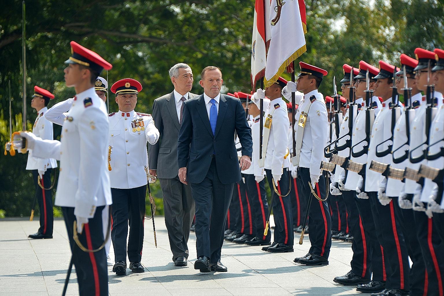 Mr Tony Abbott inspecting the guard of honour with PM Lee Hsien Loong at the Istana yesterday, during the Australian Prime Minister's two-day official visit to Singapore.