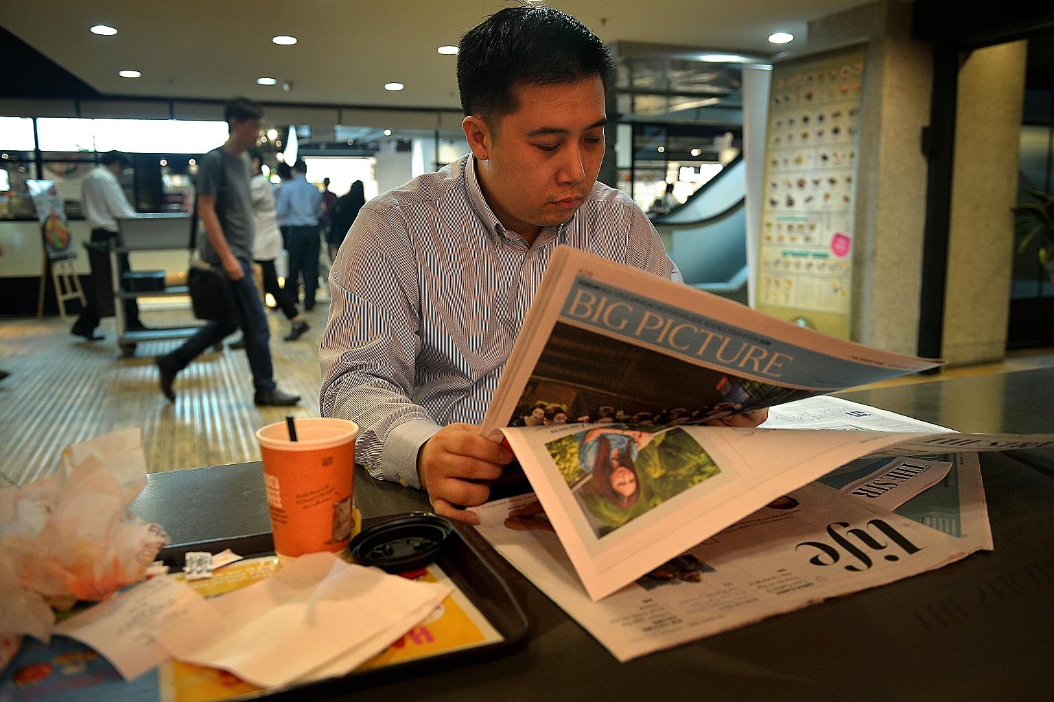 Insurance agent Joshua Lim, 45, reading a copy of the newly relaunched Straits Times yesterday. He liked the new Page Two, which gives readers a summary of the news at a glance and includes a short column explaining a news topic.