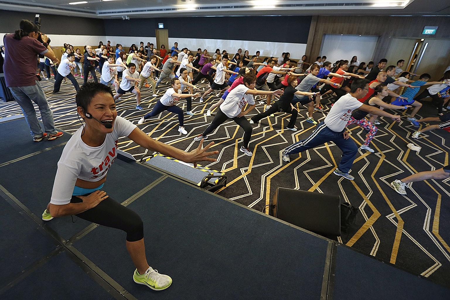 Senior Minister of State for Transport Josephine Teo (in front row) joining Travel Smart Rewards winners in a workout during LTA's Travel Smart Day at Suntec Singapore Convention and Exhibition Centre yesterday.