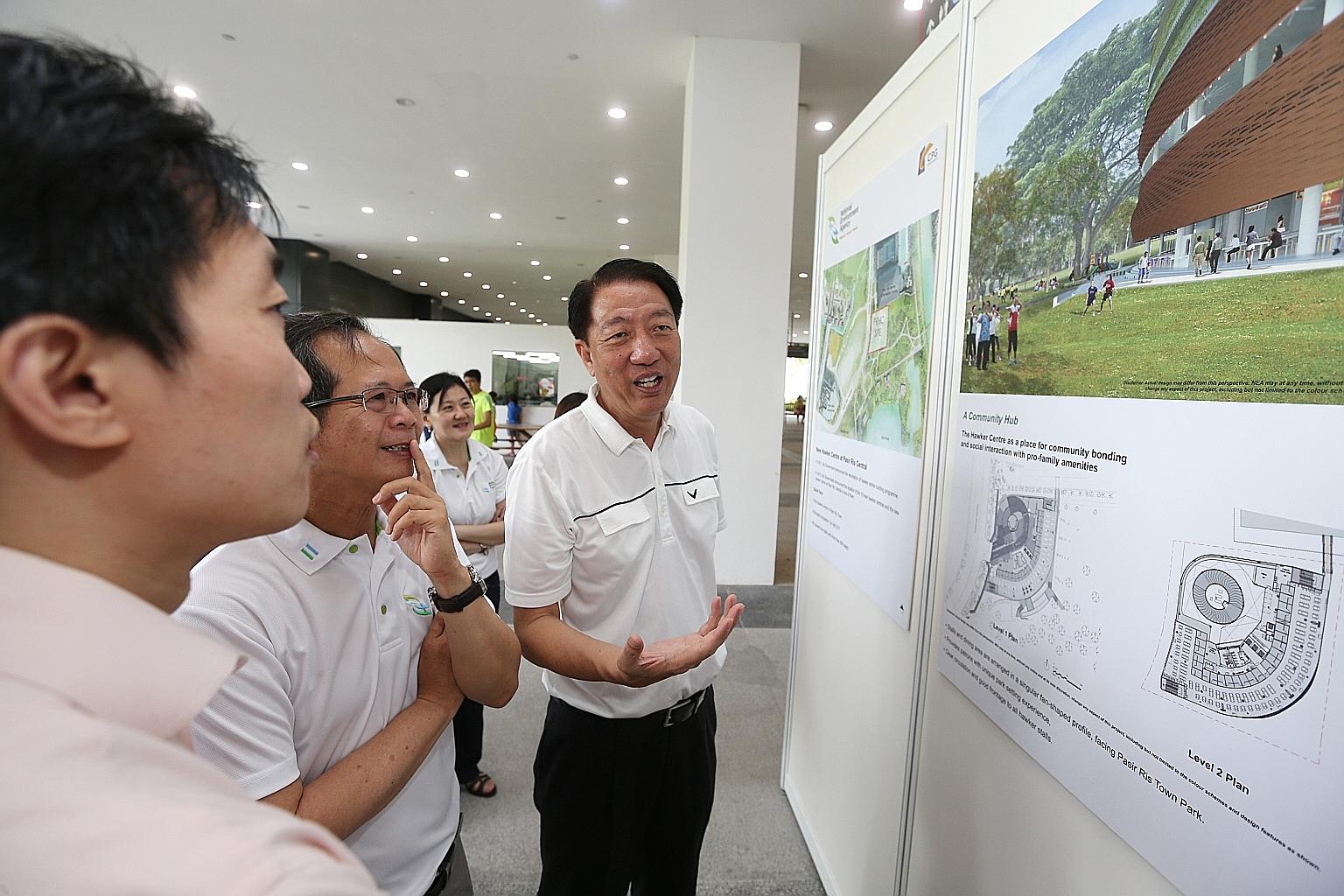 Deputy Prime Minister and MP for Pasir Ris-Punggol GRC Teo Chee Hean (right) looking at the new hawker centre's layout and artist's impressions during the ground-breaking ceremony yesterday.