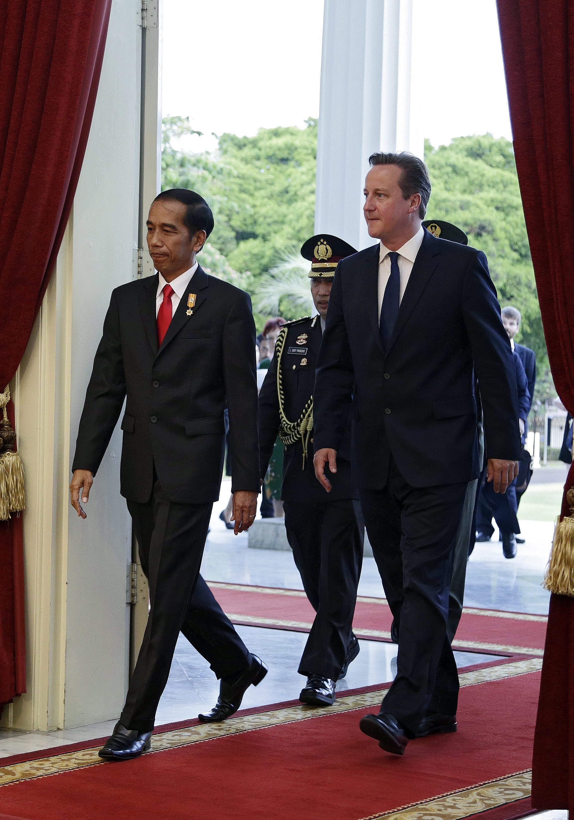 Indonesian President Joko Widodo (left) and British Prime Minister David Cameron arriving at the Presidential Palace in Jakarta yesterday. Mr Cameron arrives in Singapore today.