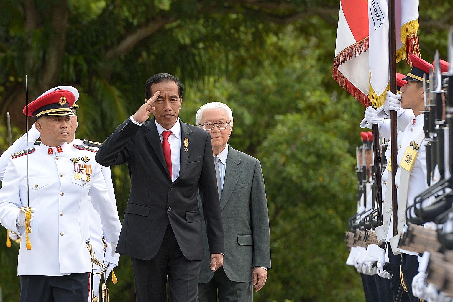 Indonesian President Joko Widodo saluting as he inspected an honour guard with President Tony Tan Keng Yam during a welcome ceremony at the Istana yesterday. Mr Joko urged investors to look to Indonesia, where he says "a new economic cycle is beginni
