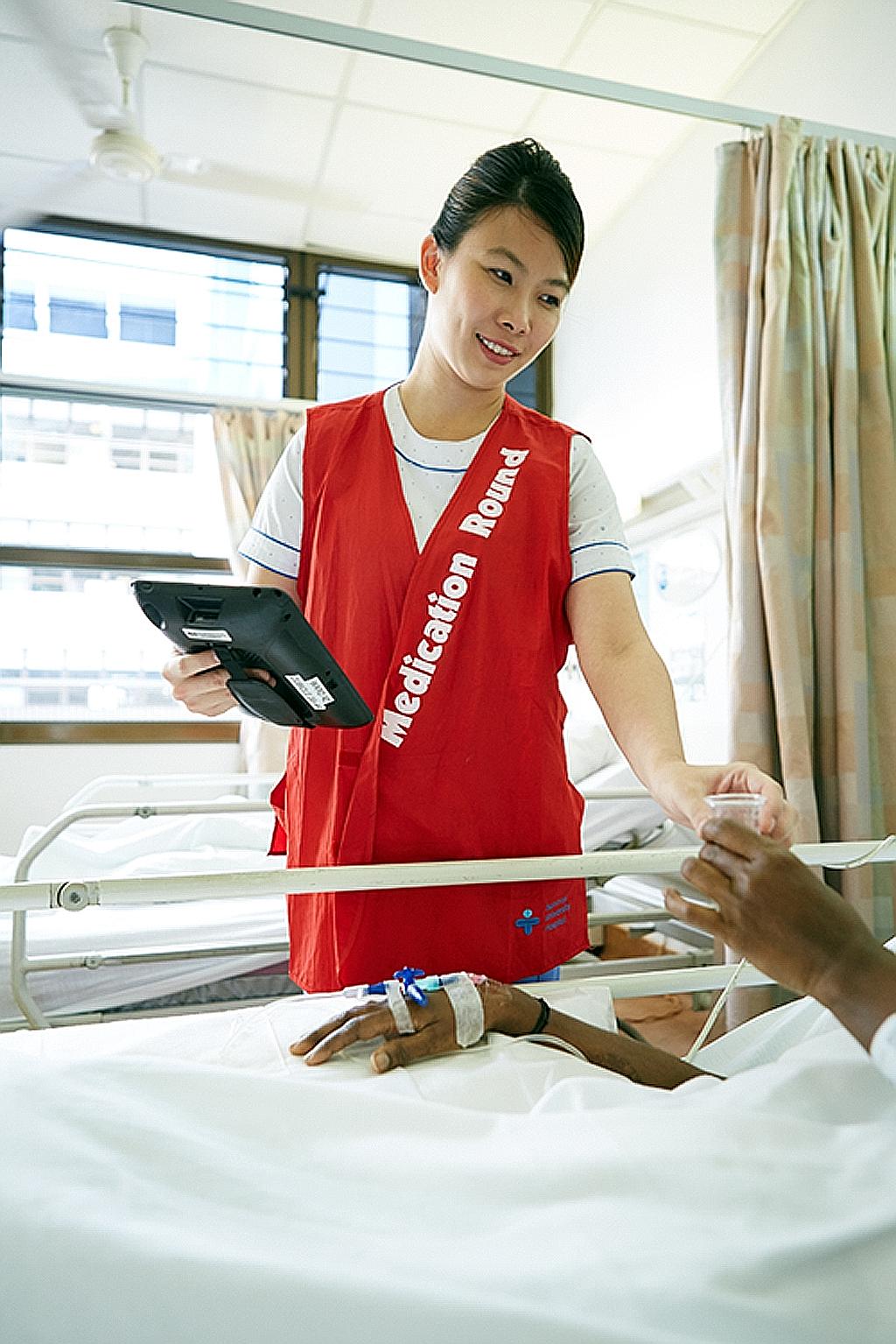 Staff Nurse Sapphire Teo giving medication to a patient. Nurses today are better educated and have structured career tracks and the autonomy to make clinical decisions.