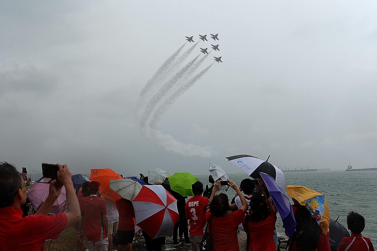 Families gathering along the coastline of Marina South to catch the Black Knights aerial display. The show was one of the events held yesterday to mark the nation's 50th birthday.