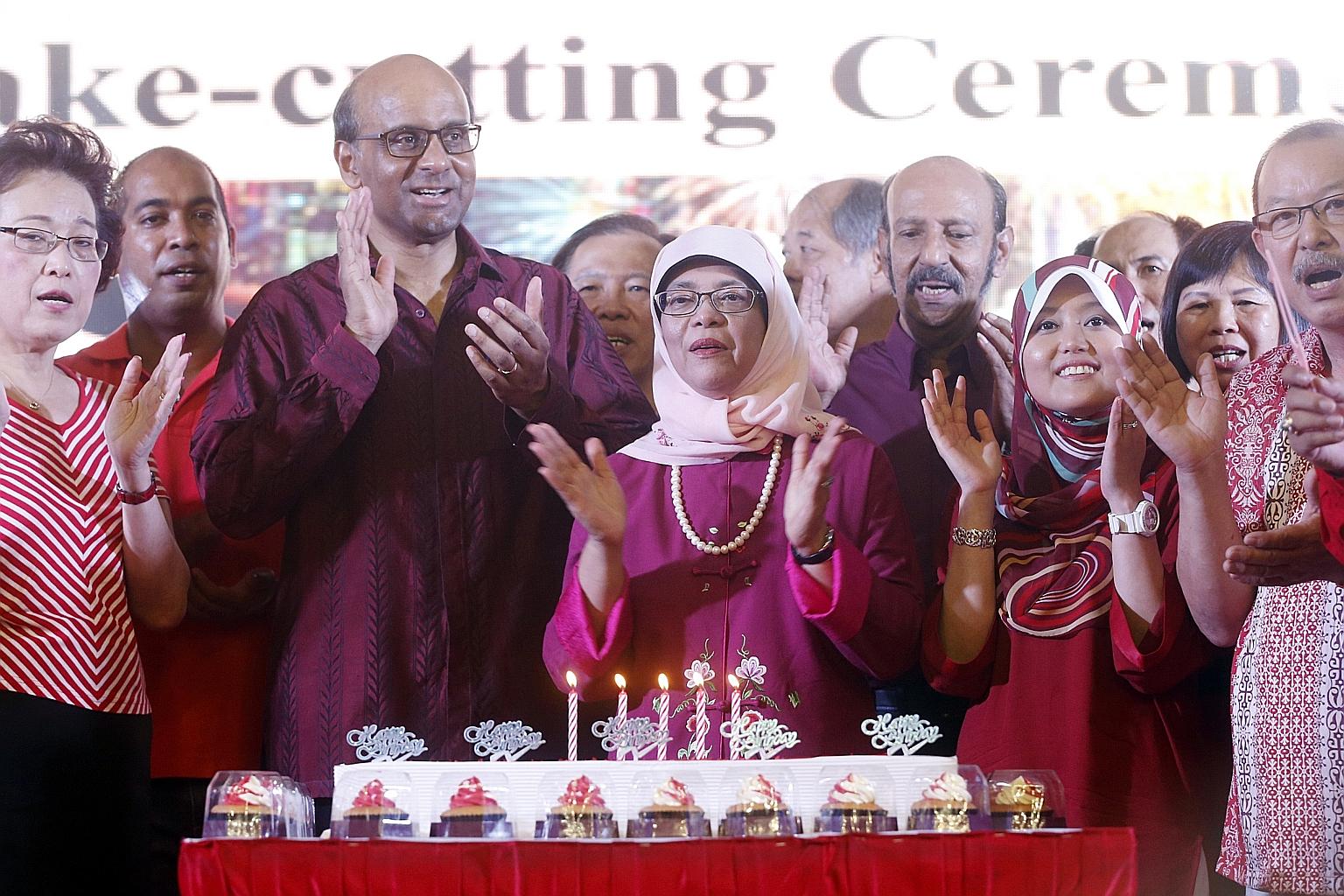 Deputy Prime Minister Tharman Shanmugaratnam (third from left), Madam Halimah Yacob (centre), and Madam Rahayu Mahzam (third from right) attended a National Day dinner in Bukit Batok yesterday. Madam Rahayu will replace Madam Halimah in Jurong GRC.