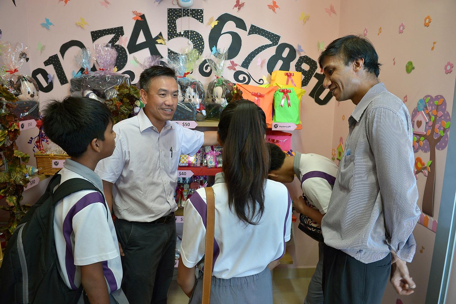 NorthLight School principal Martin Tan (left) and mathematics teacher Raj Kumar Naidu Rajamoney with students at the school's gift shop before its official opening last week. Mr Tan, who became the school's principal in 2011, says he empathises with
