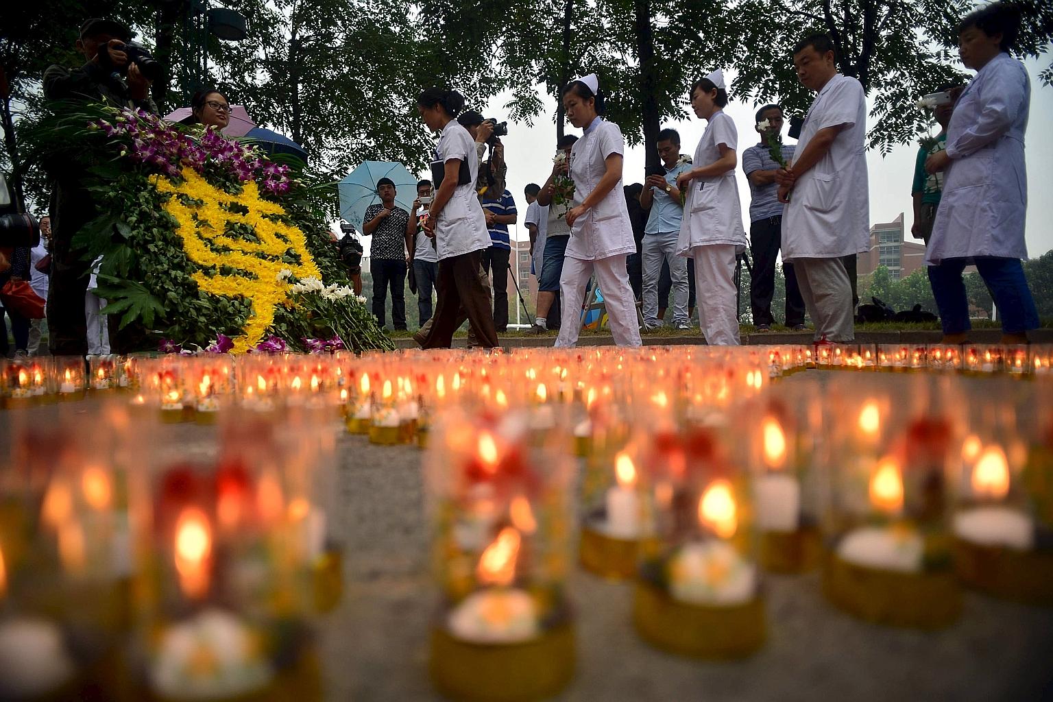 Medical workers paying tribute to the people who died in the Tianjin explosions at a ceremony yesterday to mark the seventh day after the disaster.