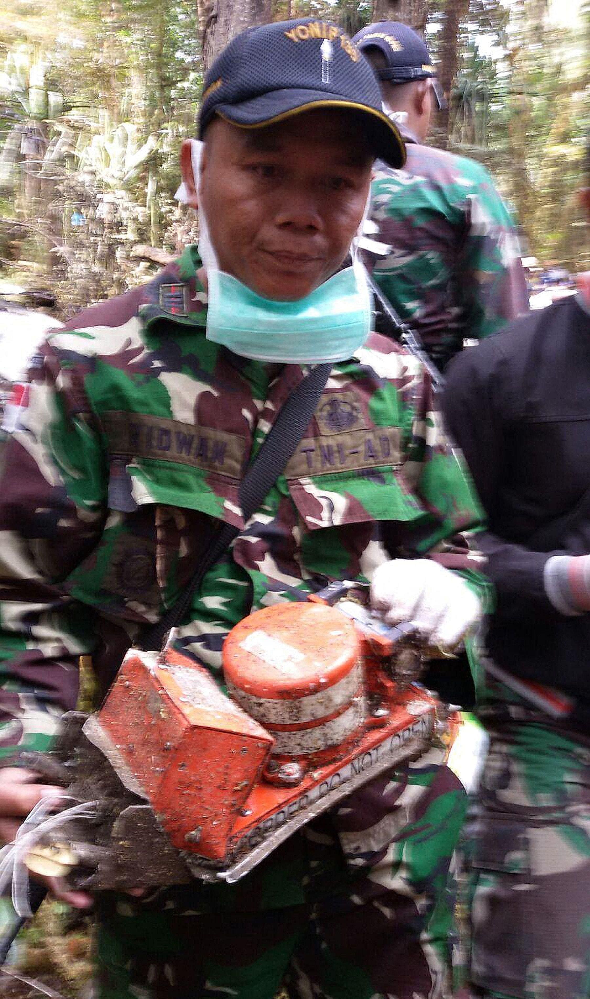 A soldier holding a recovered black box flight data recorder from the Trigana Air plane that crashed in eastern Indonesia on Sunday. All 54 people on the flight perished.