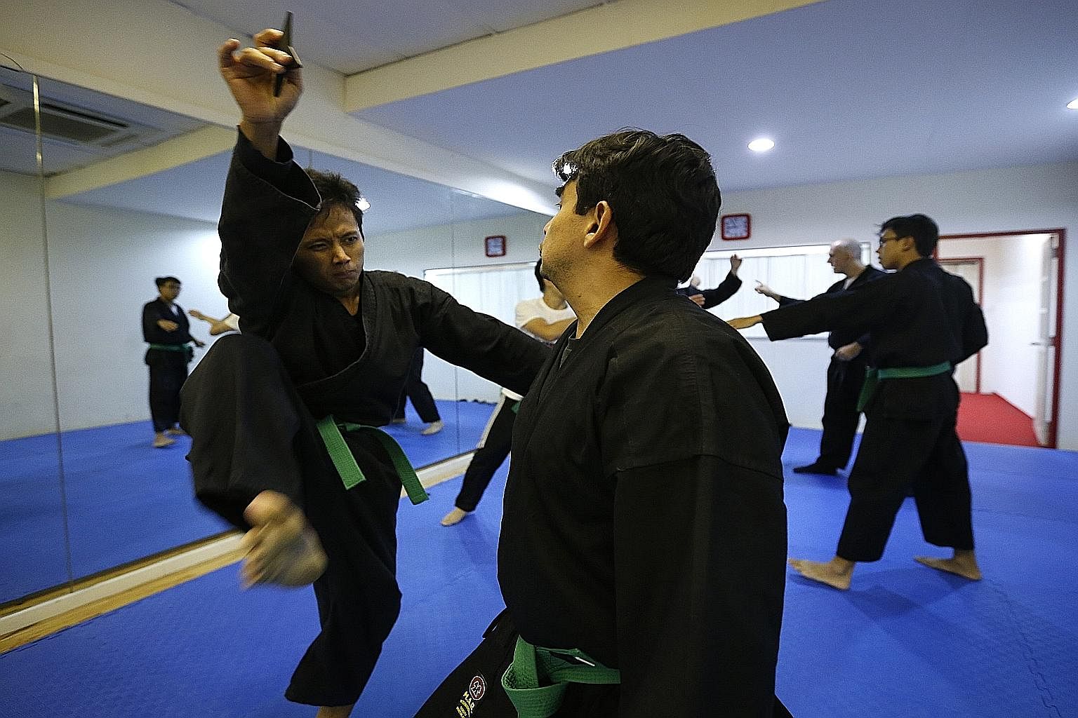 (Above) Ninjutsu student Lal Rin Lian uses a shuriken to distract his opponent - a common tactic that seeks to buy a practitioner sufficient time to take out his attacker - as he delivers a surprise kick during training. Besides striking, grappling, 
