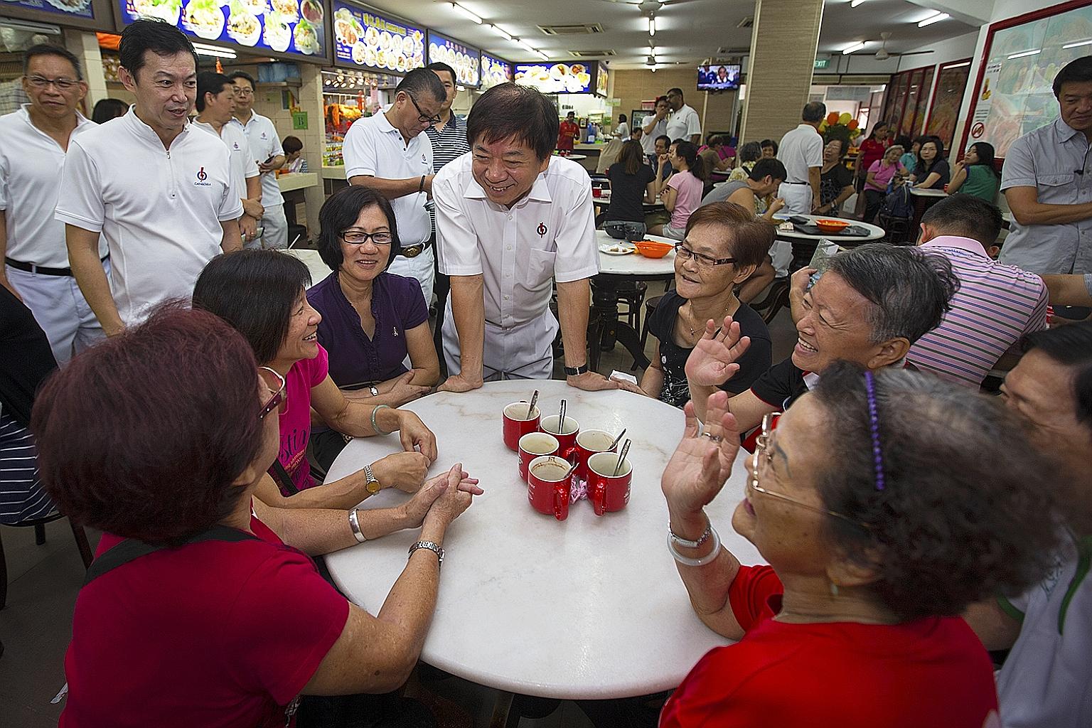 Mr Khaw Boon Wan speaking to diners at an eatery during his walkabout in Woodlands yesterday.
