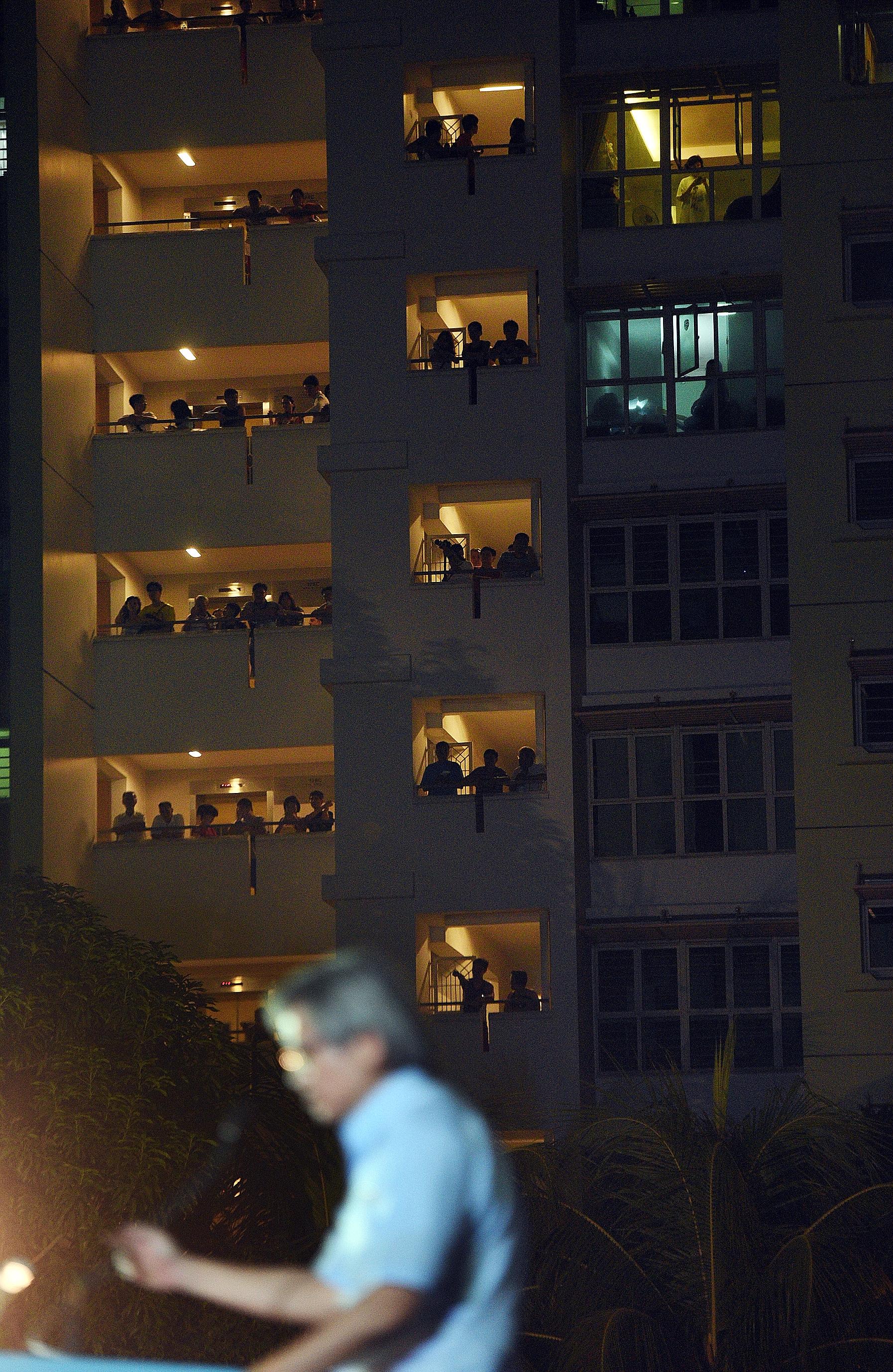 People at a nearby HDB block watching Workers' Party candidate Chen Show Mao speaking at last night's rally at Punggol Field. WP's Ms Lee Li Lian will be contesting in Punggol East SMC.