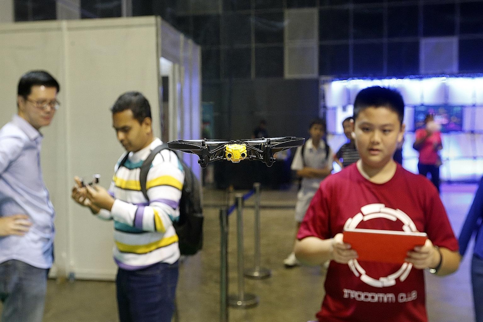 Tse Chung Man, 14, flying a mini-drone in the "Drone Zone" at the Infocomm Development Authority's Young Tech Fest. Other visitors were there to try out different technologies or take part in free workshops.