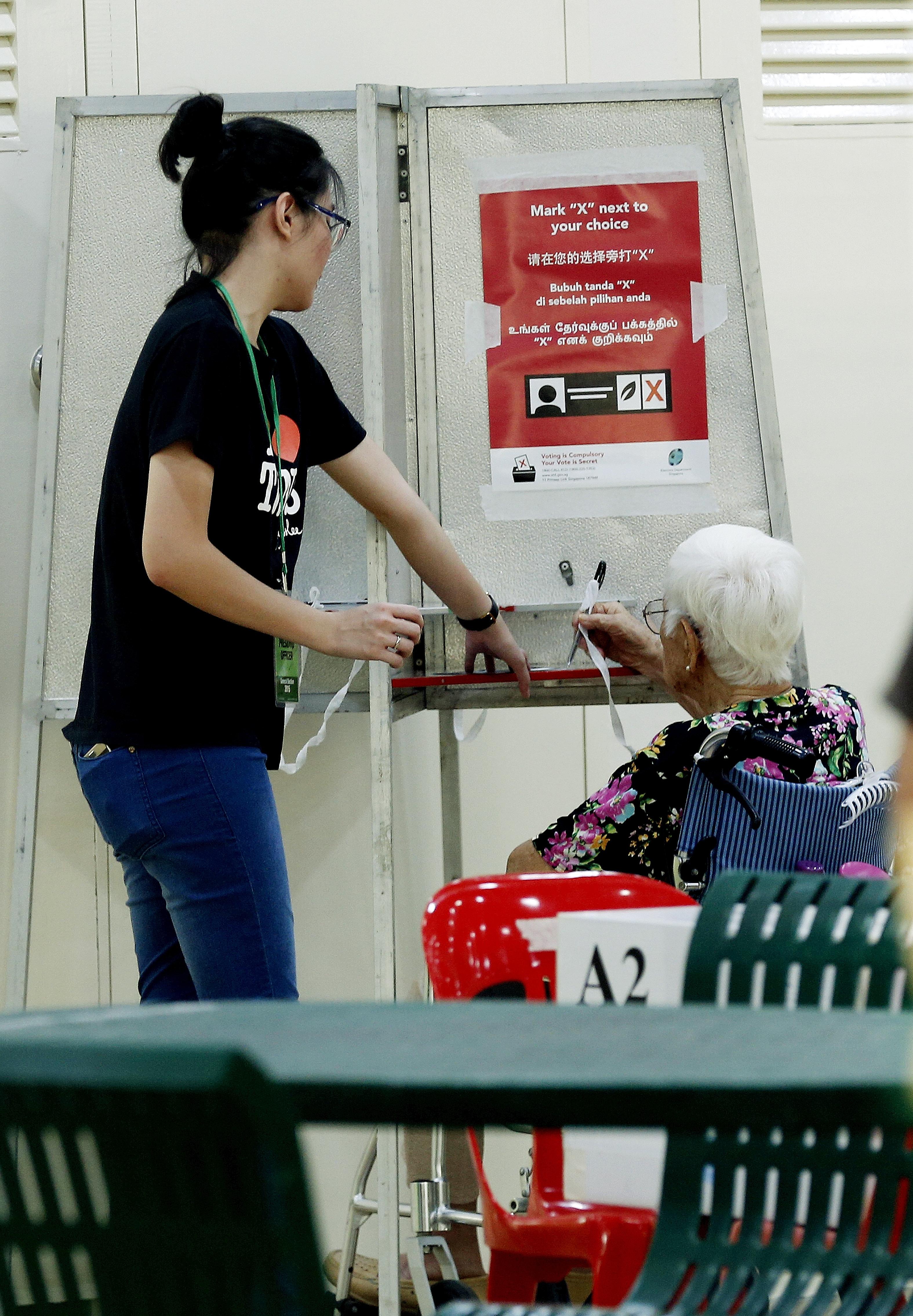Resident Ho Ku Wan, 94, casting her vote at a polling station in Toa Payoh. Since GE2011, the PAP has provided more help for the low- and middle-income groups as well as the elderly.