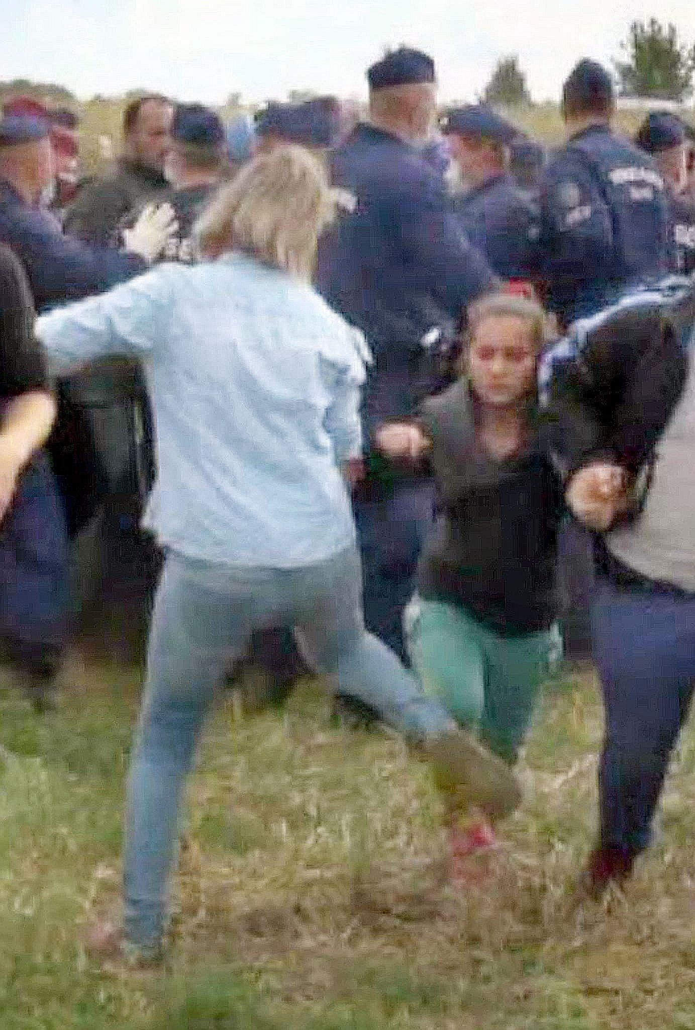 This video grab shows Hungarian TV camerawoman Petra Laszlo kicking a child as she runs with other migrants from a police line during disturbances at Roszke, southern Hungary. Ms Laszlo was fired after the footage went viral.