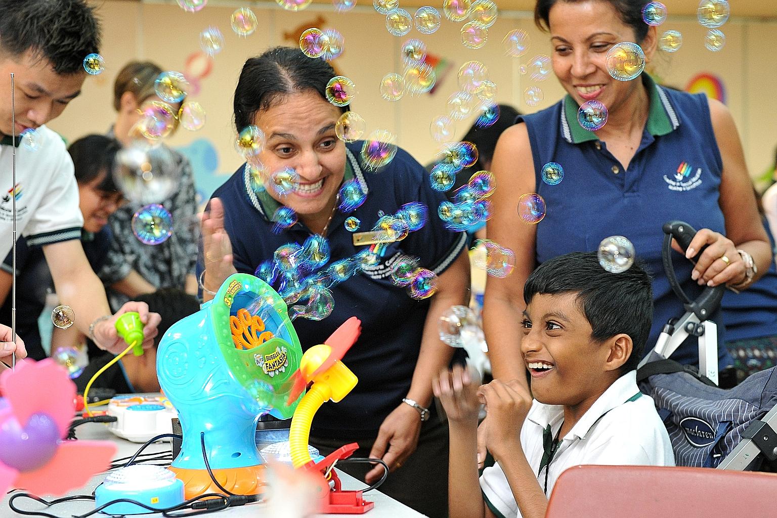 Ashfaq Ahmad Mohammed Ismail, nine, playing with a modified bubble-blowing machine at the SG50 Hack-A-Toy! event at the Rainbow Centre's Margaret Drive School yesterday.