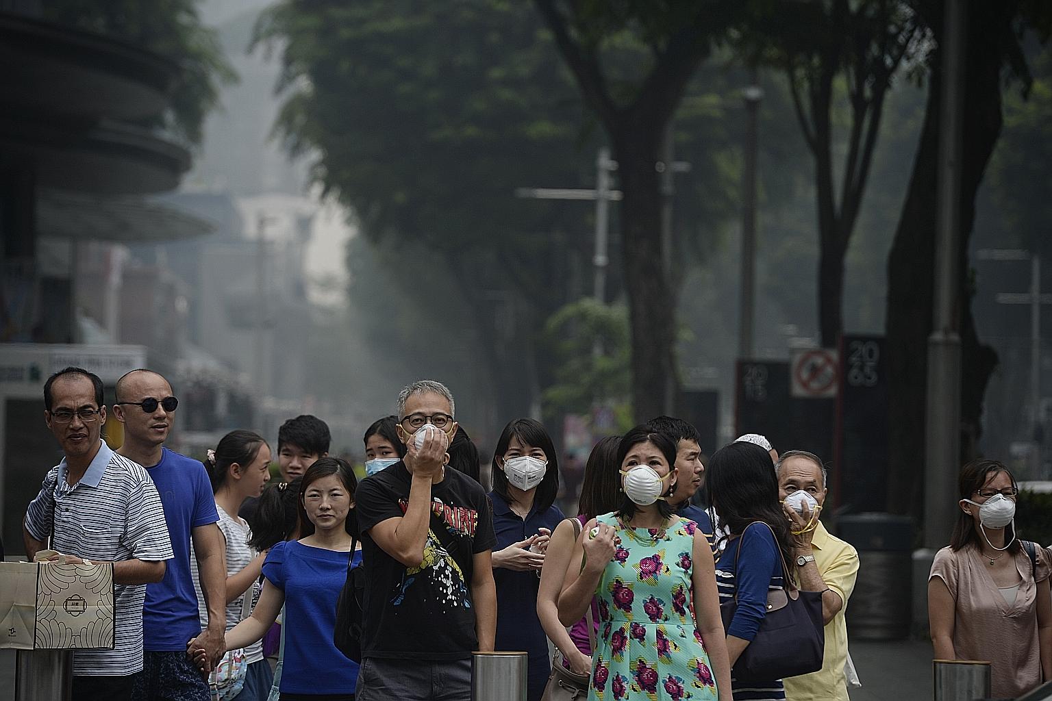 Shoppers put on masks in Orchard Road yesterday afternoon. At 10pm, the 24-hour PSI had soared to 223-275. Beyond 300, it is hazardous.