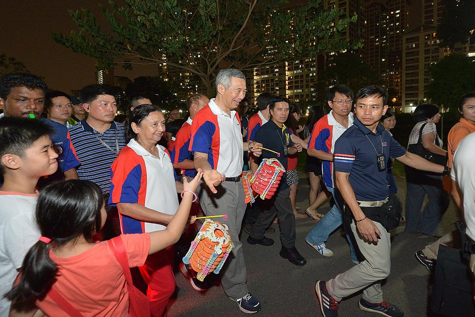 Prime Minister Lee Hsien Loong joining residents in a lantern procession at Bishan-Ang Mo Kio Park last night. Mr Lee said he hoped "we will have a good year ahead and next year will be better".