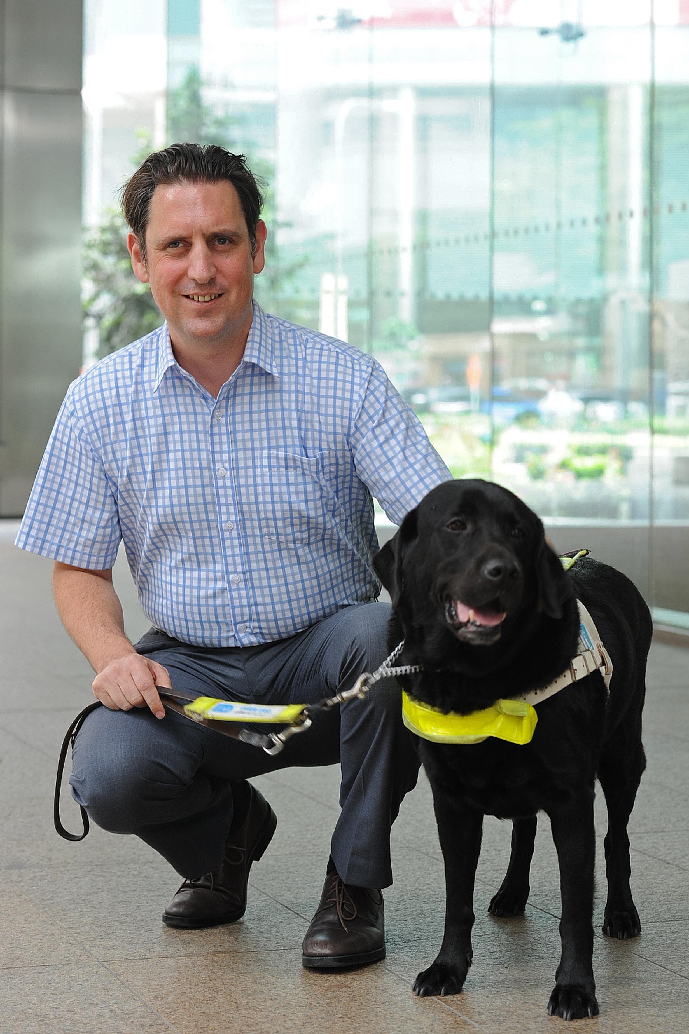 Guide Dogs Association of the Blind chairman Amos Miller, who is blind, with his guide dog Trevor. He hopes to raise the number of people using guide dogs here from seven to 30 or 40 in the next few years.