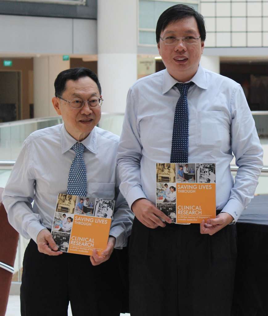 Professor Woo Keng Thye (far left), an emeritus consultant at Singapore General Hospital, and Associate Professor Teoh Yee Leong, chief executive of the Singapore Clinical Research Institute, with copies of the commemorative book celebrating the progress 