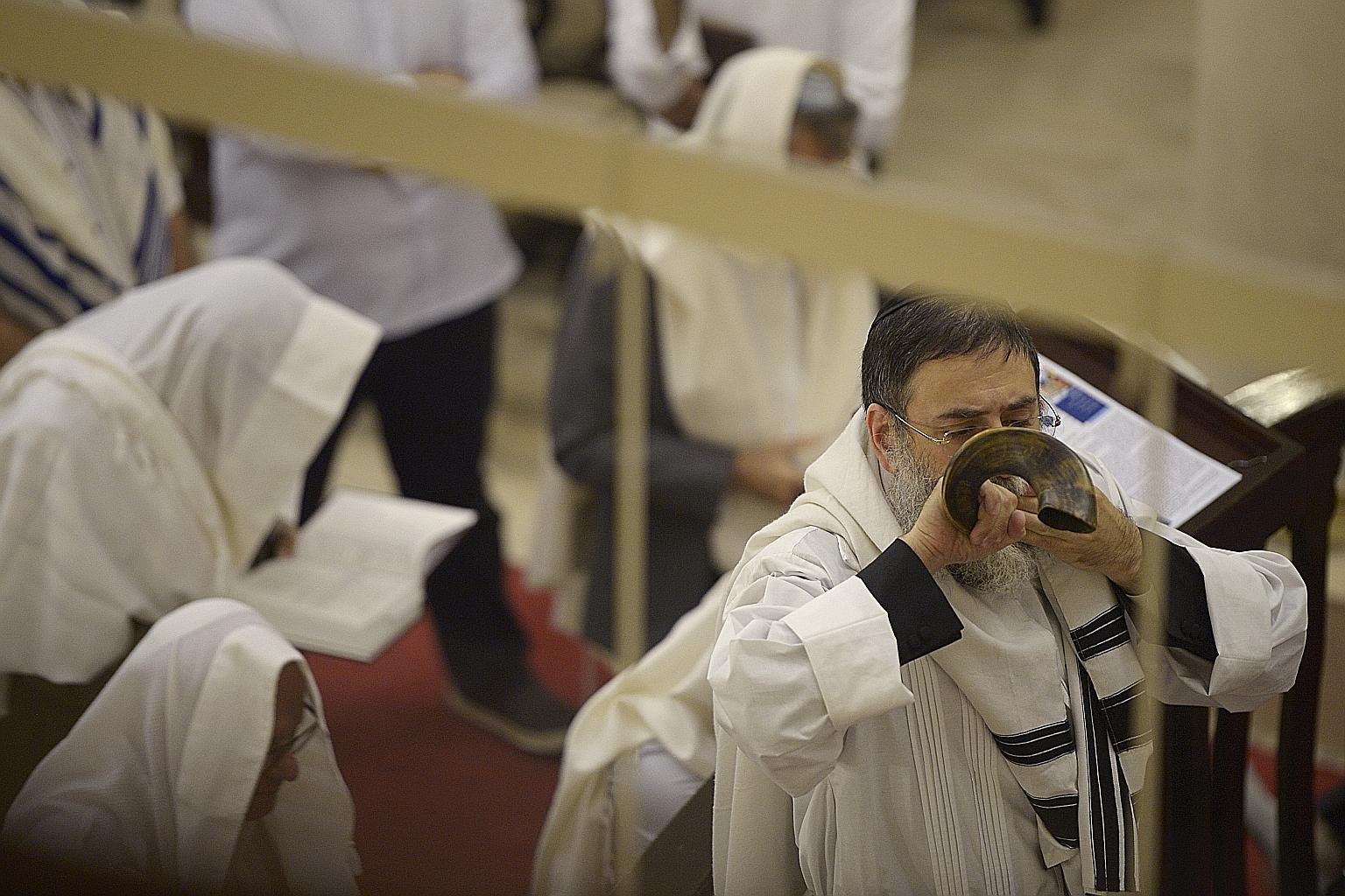 Rabbi Abergel (above) blows the Shofar - a traditional instrument made from the horn of a ram - to mark the end of the fasting period.