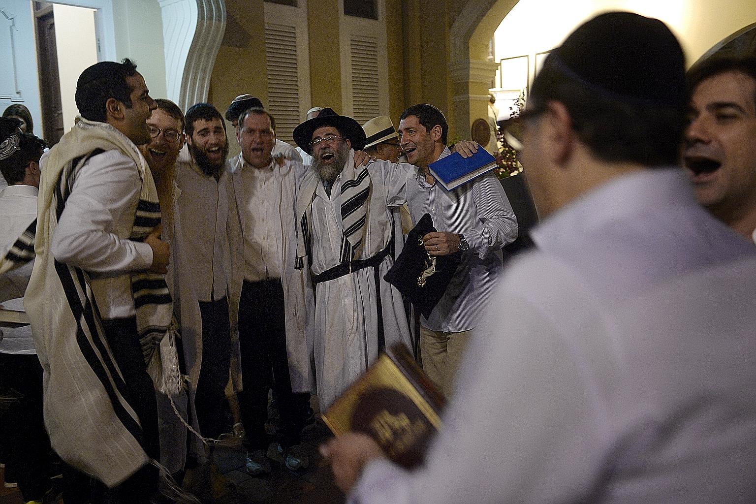 Rabbi Mordechai Abergel (centre, wearing a hat) and other men from the Jewish community dance and sing to celebrate the end of the fasting period during Yom Kippur – the holiest festival in the Jewish calendar – at the Maghain Aboth Synagogue in Waterloo