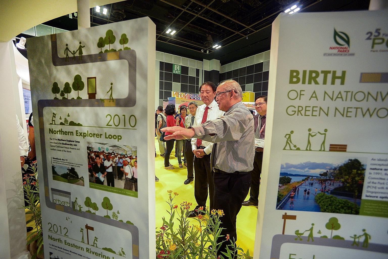 Deputy Prime Minister Teo Chee Hean viewing an exhibit of Singapore's park connector network with National Parks Board assistant director Henry Hee yesterday. Mr Teo was the guest of honour at the opening of the exhibition on the public service's pas