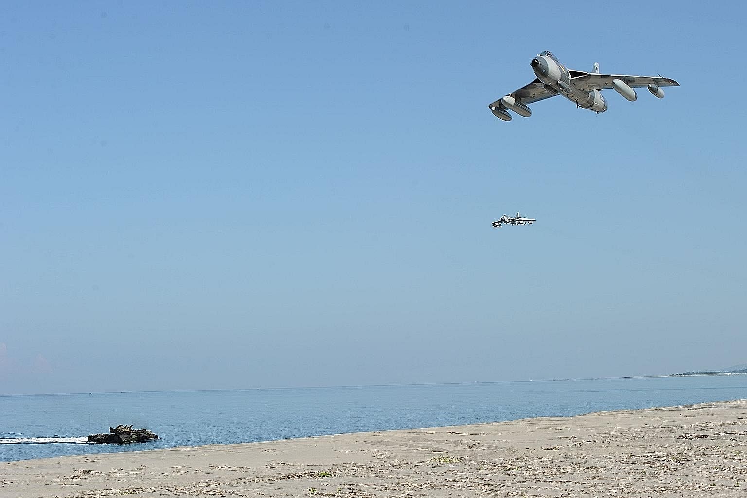 US Marine MK-58 Hawker Hunter fighter jets flying over an assault amphibious vehicle during an amphibious landing exercise as part of an annual joint US-Philippines naval exercise facing the South China Sea in San Marcelino, north of Manila, last Fri