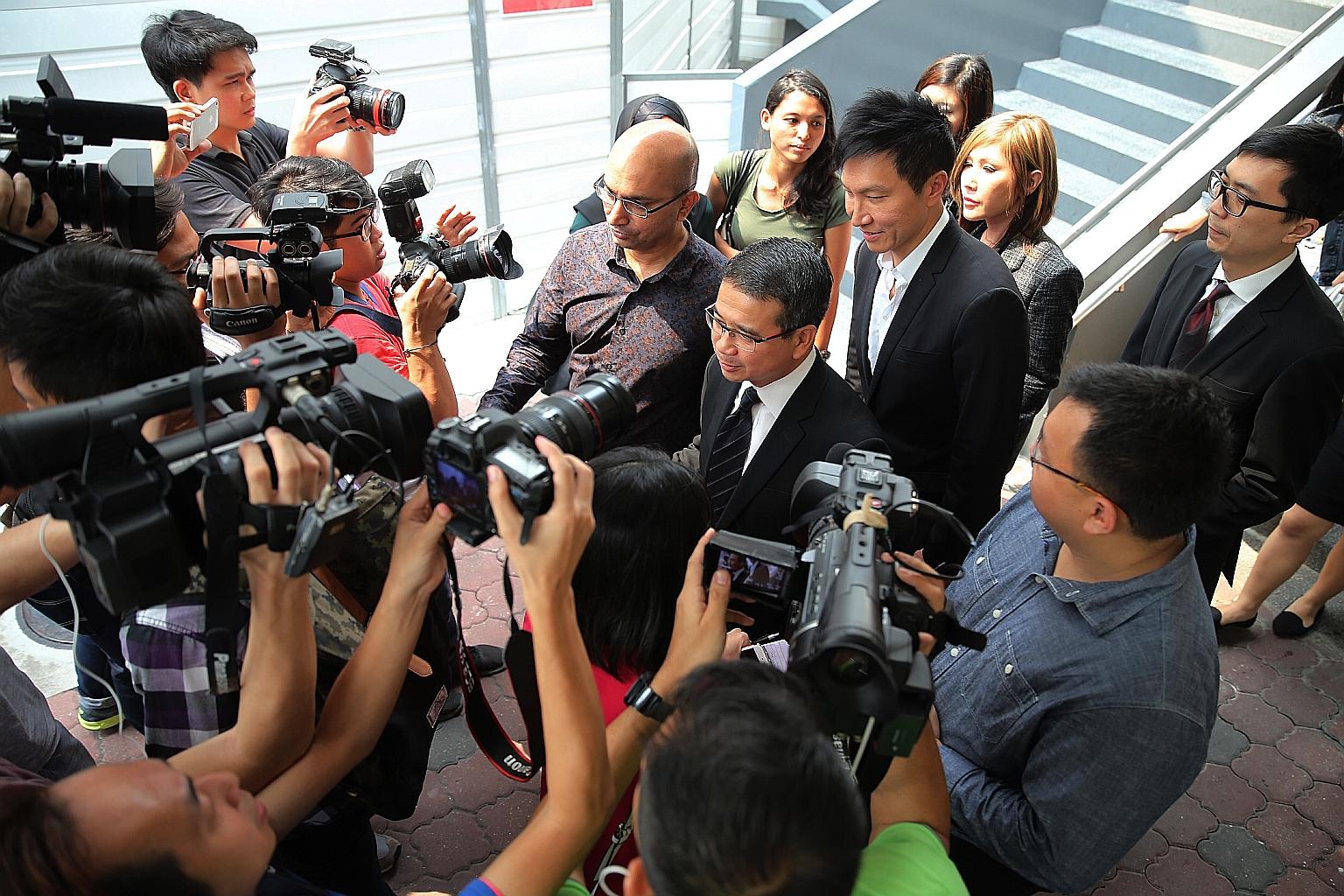 Lawyer Edwin Tong (facing the media, with tie), Kong Hee (behind Mr Tong) and Kong's wife Ho Yeow Sun (behind Kong) leaving the courts on Wednesday. Kong and five others were on Wednesday convicted of misusing some $50 million in City Harvest Church