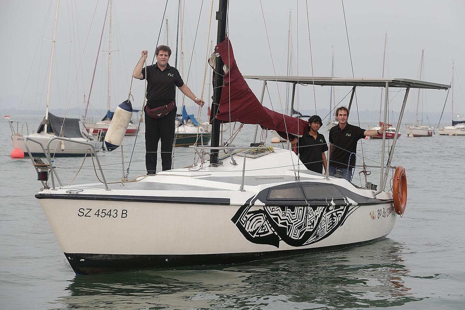 (From left) Dr Joerg Weigl, Mr Anand Sundaram and Associate Professor Martin Henz on board the Bo Bo Cha Cha at Changi Sailing Club. Without using its sail, the zero-carbon boat can travel for five hours non-stop, with a full speed of 5 knots, or abo