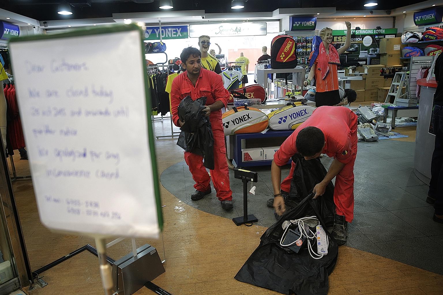 Workers clearing damaged items at Sports Life. The fire last Saturday originated in a storeroom of the sports equipment store.