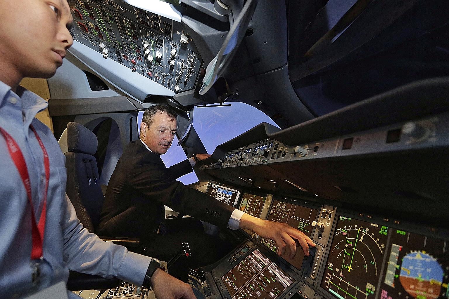 Capt Lardet giving a tour of the A350 flight simulator to the media at the Airbus Asia Training Centre (AATC), located in the SIA Training Centre, yesterday. The AATC will move to its own premises in Seletar next year.