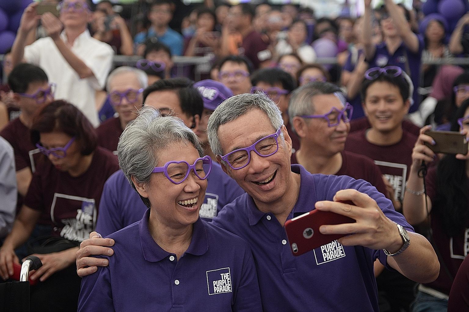 Donning purple spectacles, Prime Minister Lee Hsien Loong takes a selfie with his wife Ho Ching as they join participants at The Purple Parade held in Hong Lim Park. More than 7,000 people attended the event yesterday.