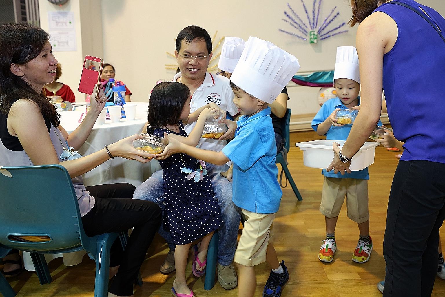 Tan Yi Hang (centre), six, handing a box of rojak to his mother at the graduation ceremony in Punggol View Primary School. About 100 children, their parents and teachers gathered to celebrate the completion of their pre-school education.