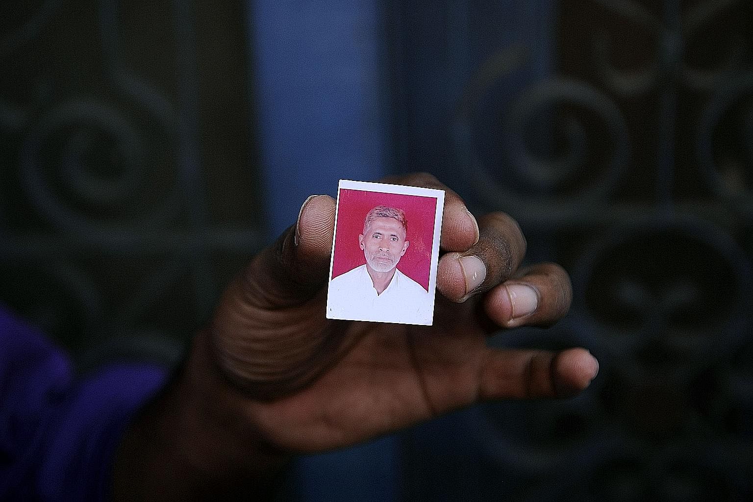 A relative shows a photograph of slain Indian villager Mohammed Akhlaq Saifi at his home in the village of Bisara, after his death in September at the hands of a mob in the northern state of Uttar Pradesh.