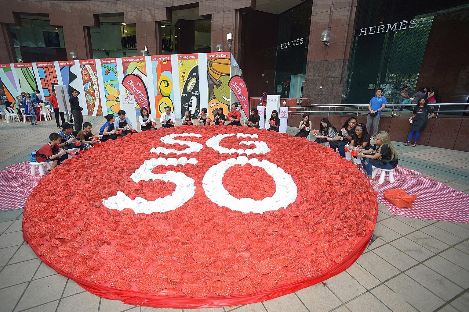 Participants at Ngee Ann City Civic Plaza putting the final touches to Durian Art, made up of husks from about 600 durians, for the Singapore WoW (Works of Wonder) exhibition.