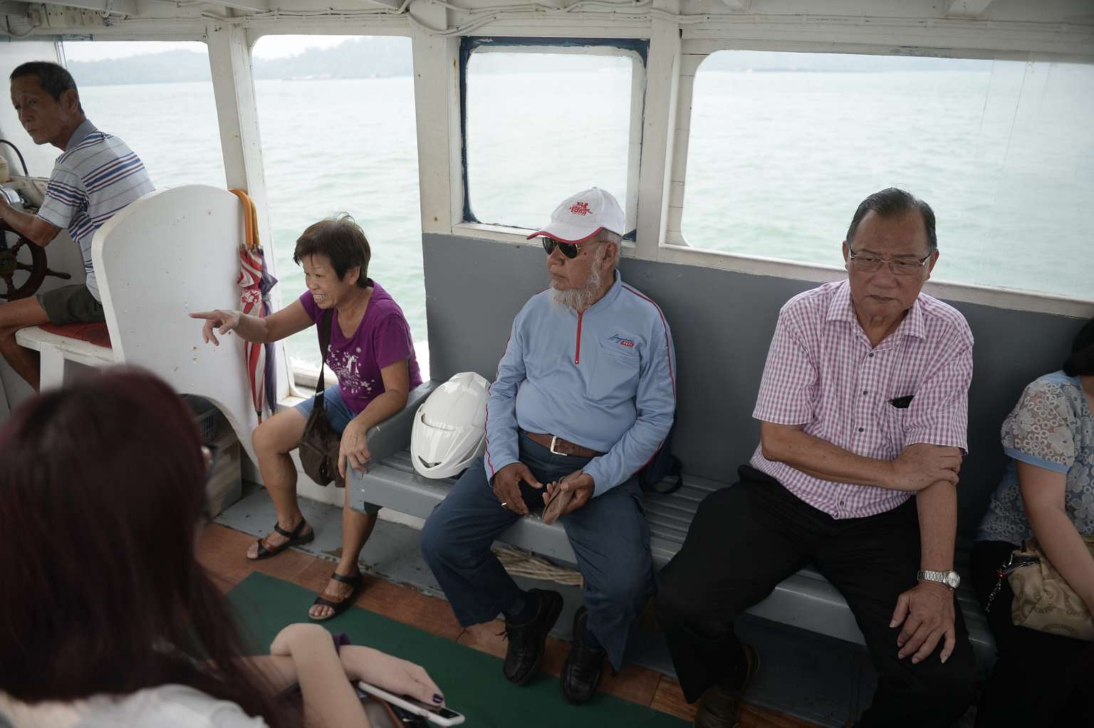 Mr Haron Jomahat (centre) takes a boat five days a week to Pulau Ubin, where he delivers mail to about 50 buildings.