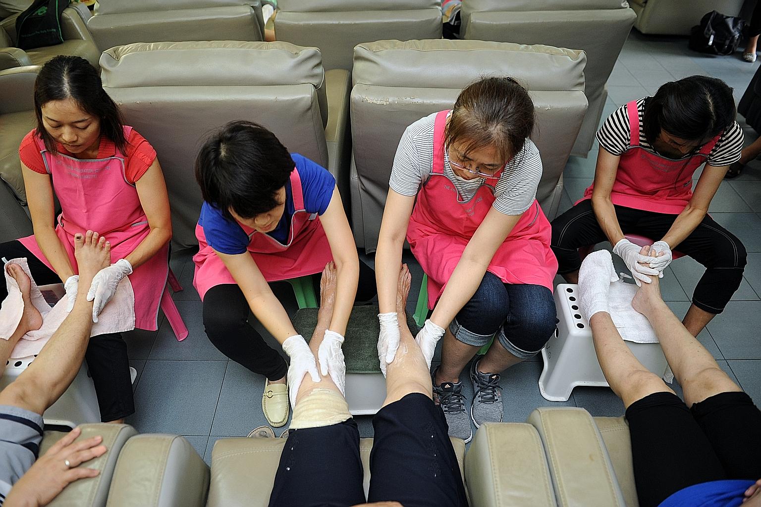 Expatriates (from left) Kazuko Okuyama, Tomoko Tsubone, Yoshie Ishida and Miki Arai giving patients at Assisi Hospice massage therapy, as part of a volunteer programme run by the Japanese Association Singapore.