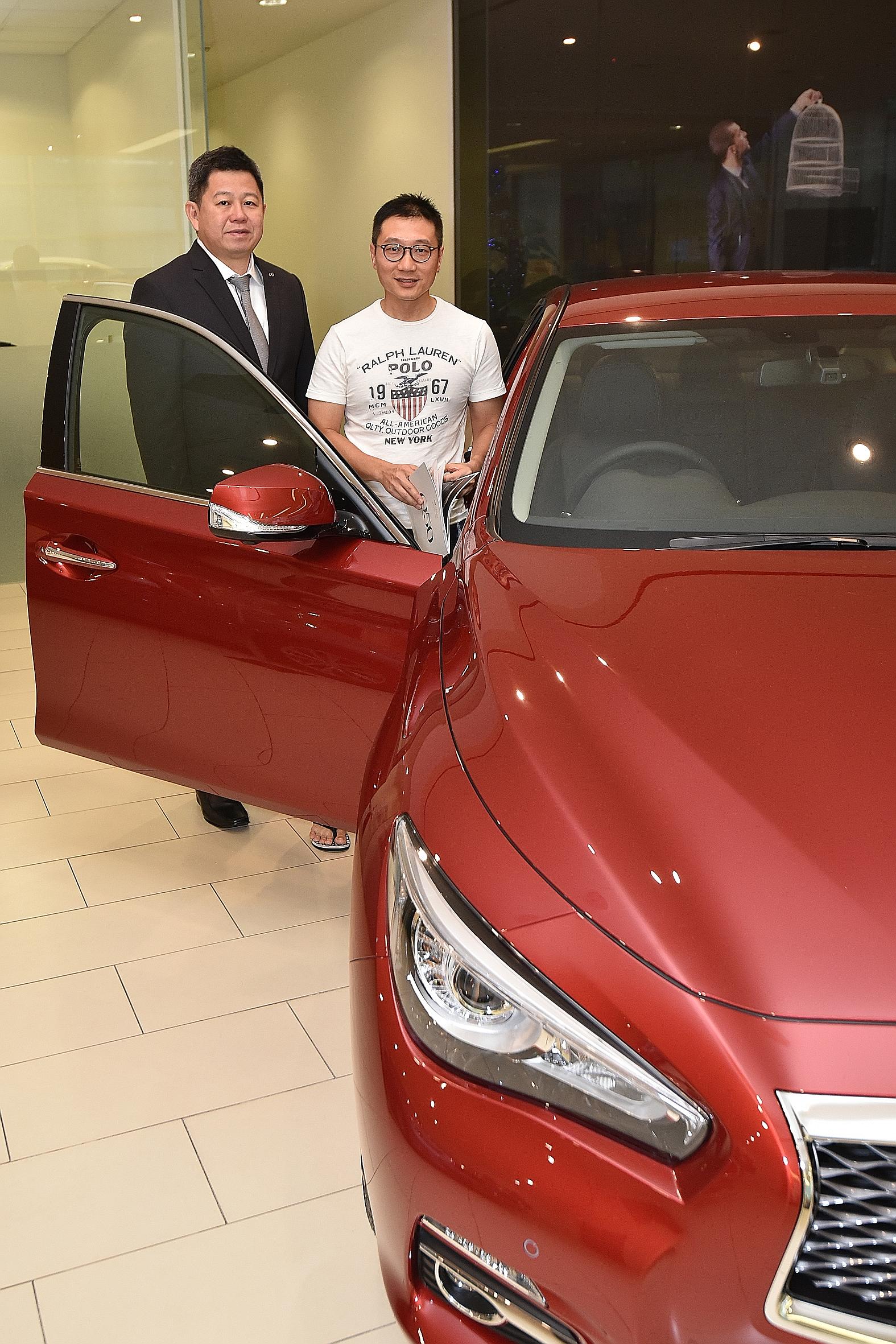 Mr Tan Chang Hong (in white T-shirt) did not let the heavy rain deter him from going to the Infiniti showroom in Leng Kee Road for a test drive of the Infiniti Q50 car yesterday. By doing so, Mr Tan, 47, seen here with Mr Michael Tan, 48, a brand con