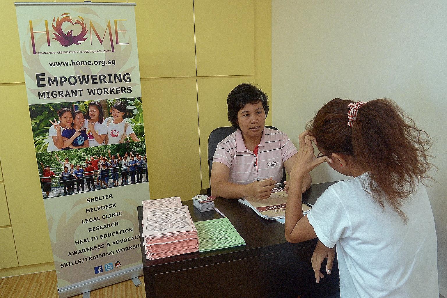 Ms Dominica Filtri Masniari (facing camera), a finance and audit manager with the Humanitarian Organisation for Migration Economics, chatting with a migrant worker at its new centre at Grandlink Square in Guillemard Road. The other new centre is at P