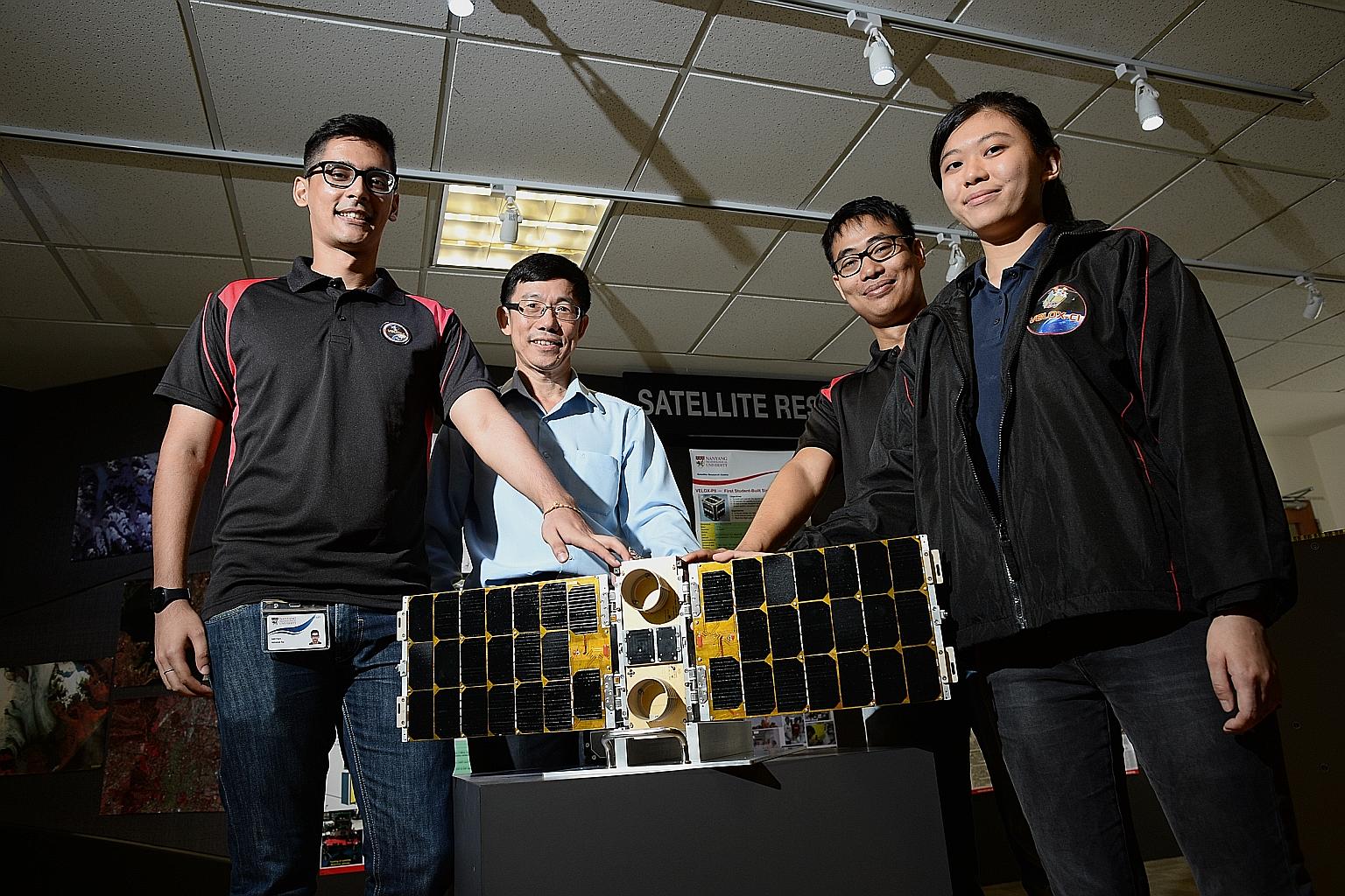 Satellite Research Centre's Associate Professor Low Kay Soon (second from left) and research engineers (from far left) Abhishek Rai, Htet Aung and Chin Shi Tong with a scale model of a satellite.