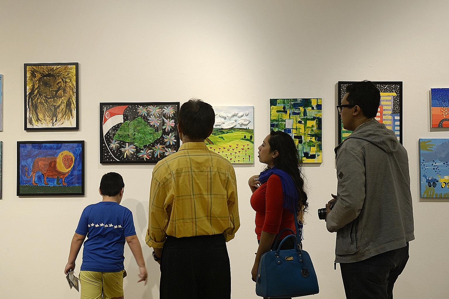 Visitors admiring paintings at Gifts, an exhibition by students from special-needs school Rainbow Centre, which opened at the Ion Art Gallery in Orchard yesterday. More than 100 artworks by over 40 students aged seven to 18 are on show from 10am to 9