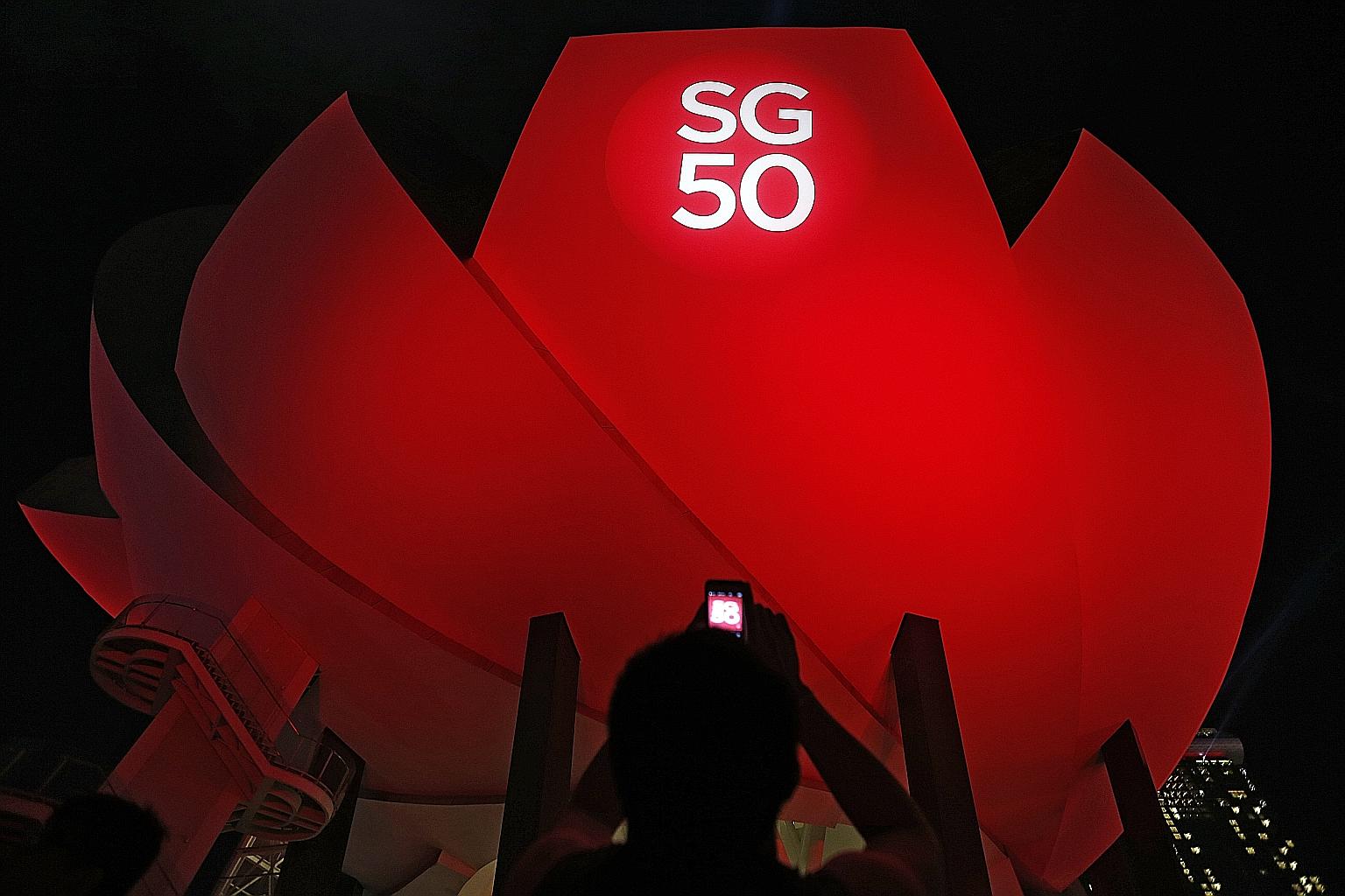 Two events that stand out this year are the death of founding prime minister Lee Kuan Yew and Singapore's golden jubilee as an independent nation. Above, left: Mourners braving the rain outside the NTUC headquarters at 1 Marina Boulevard as they wait