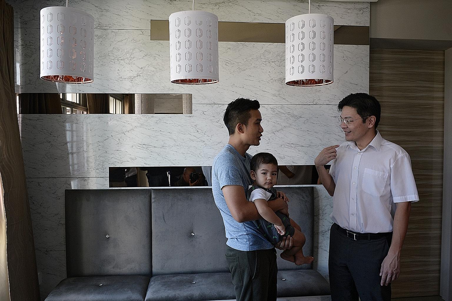 Minister for National Development Lawrence Wong visiting Tampines Greenlace resident Muhammad Hilmi Abdul Hamid, 24, seen here with his one-year-old son Ammar Muhammad Hilmi, yesterday. During the visit to the BTO project, Mr Wong told reporters that