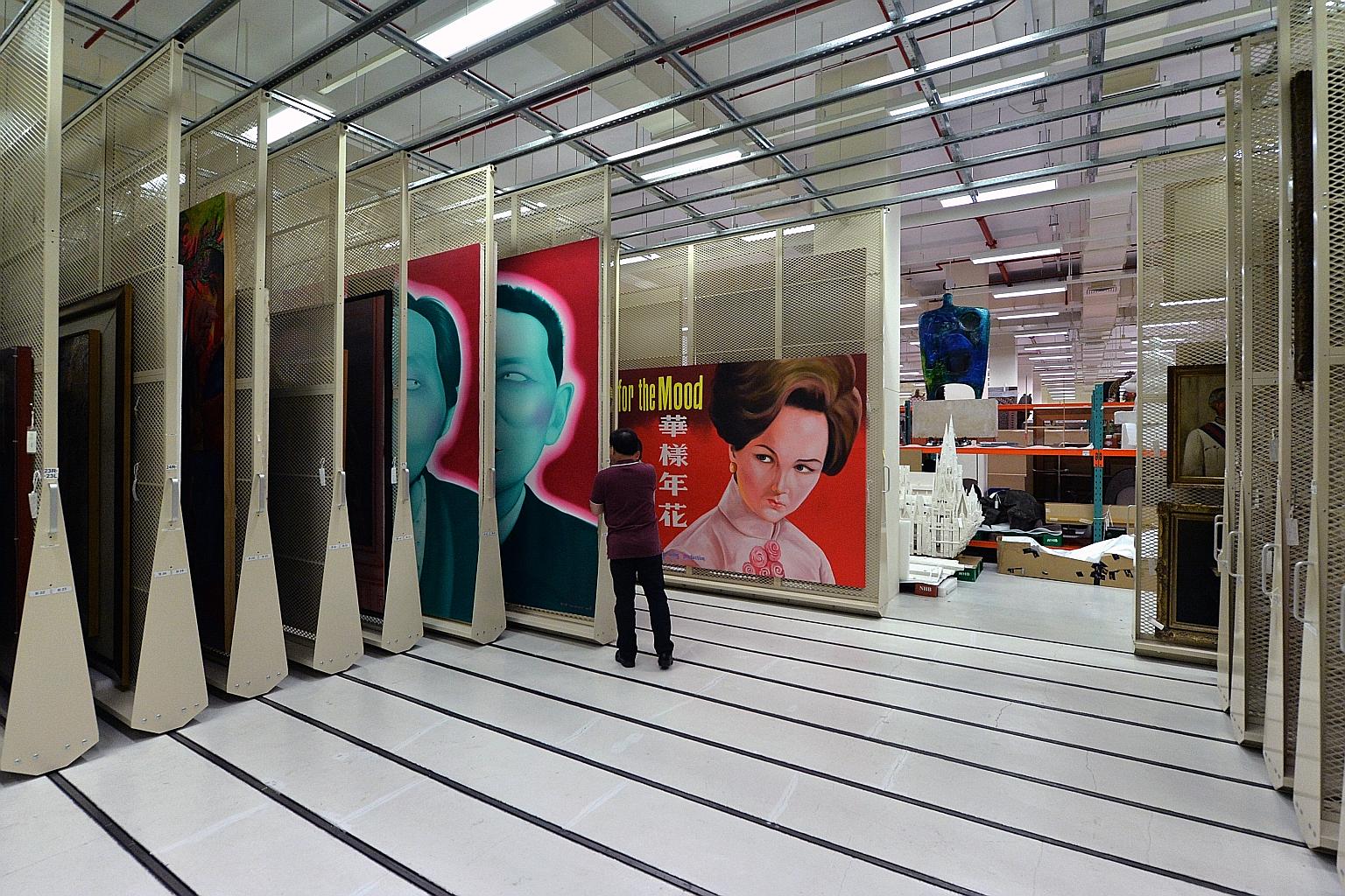 Mr Chuance Chen, Assistant Conservator (Textiles), working on an embroidered silk valance with auspicious motifs for a Peranakan wedding chamber, as well as a piece of blue damask textile with intricate raised embroidery.