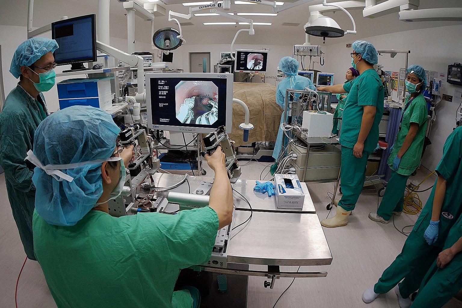 A doctor using a pincer-like device to remove tumours from a stomach cancer patient without the need for open or even keyhole surgery. Gastric cancer research was highlighted as one of the bright stars in Singapore's push to be an R&D hub.