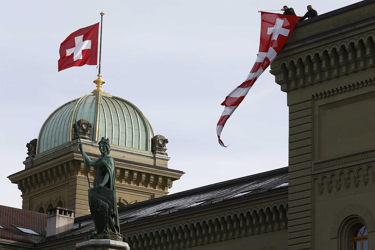 The Swiss flag waving in front of the Parliament Building in Bern.