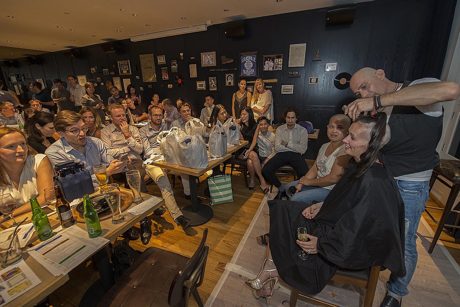 Ms Canete watches as hairstylist Joe Galeotti shaves off Ms Claisse's hair at the fund-raiser on Wednesday night